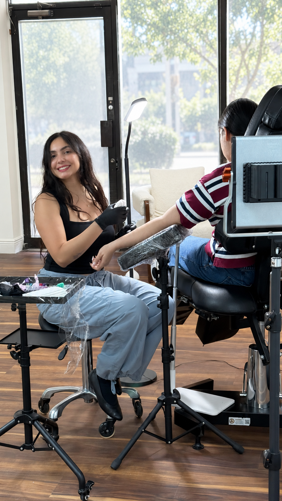 Tahia Fakher smiling while working with a client at INKTAHH